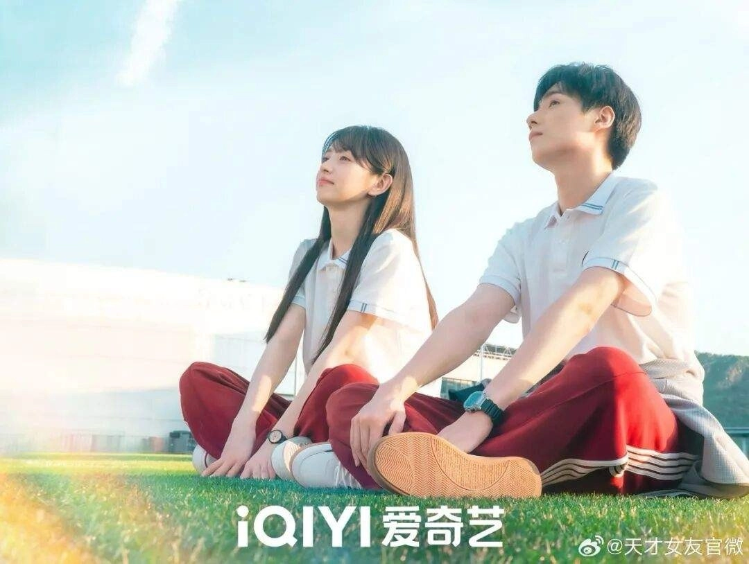 《天才女友》官方劇照，田曦薇與胡一天穿校服坐在操場草地上，青春成長劇的校園基調
